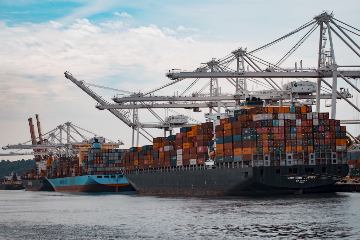 Container cranes loading ships at a cargo port at dawn