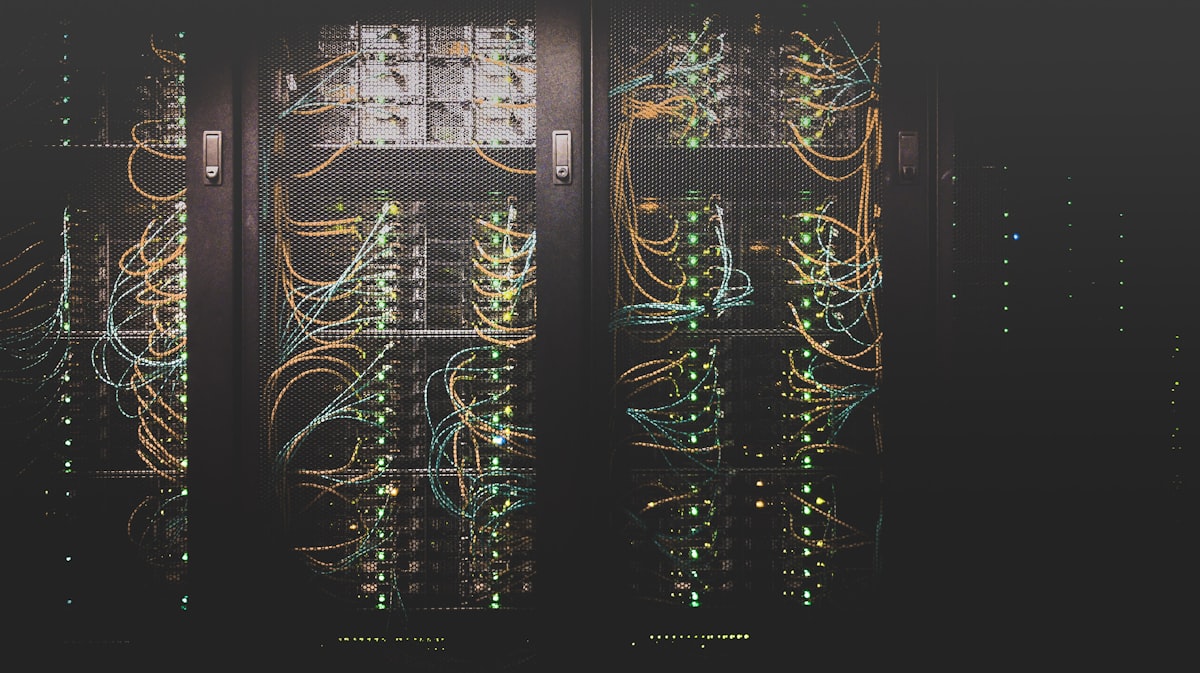 Server racks in a data centre aisle with cool lighting